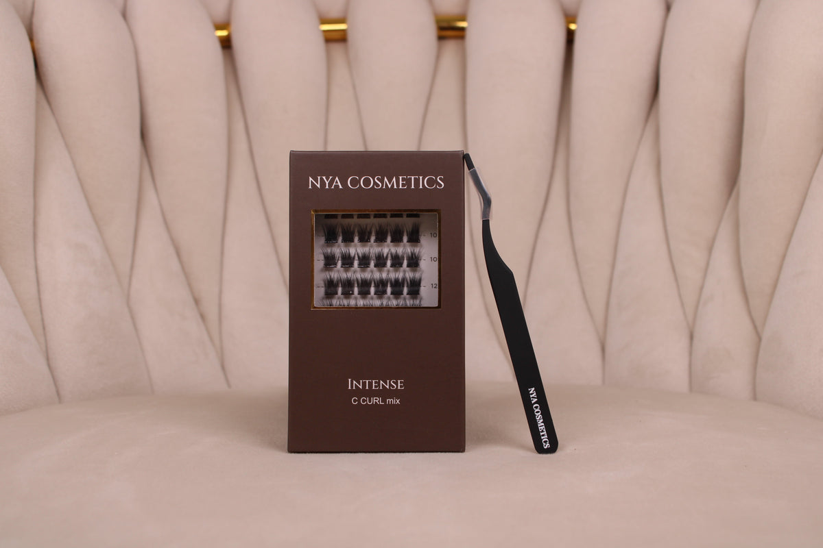 Boîte NYA Intense et pince de pose noire sur un siège beige.
