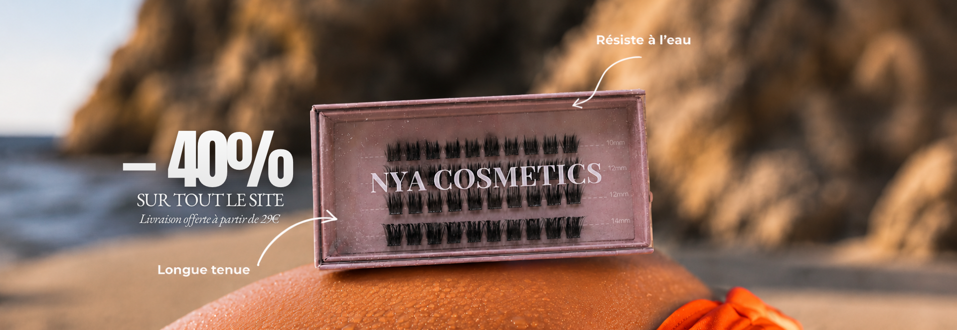 Boîte de faux cils NYA Cosmetics sur une peau bronzée avec effet mouillé, photographie lifestyle en extérieur illustrant des faux cils résistants à l’eau.