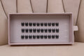 Boîte de faux cils en clusters noirs de longueur uniforme 10 mm disposés en rangées dans un plateau.