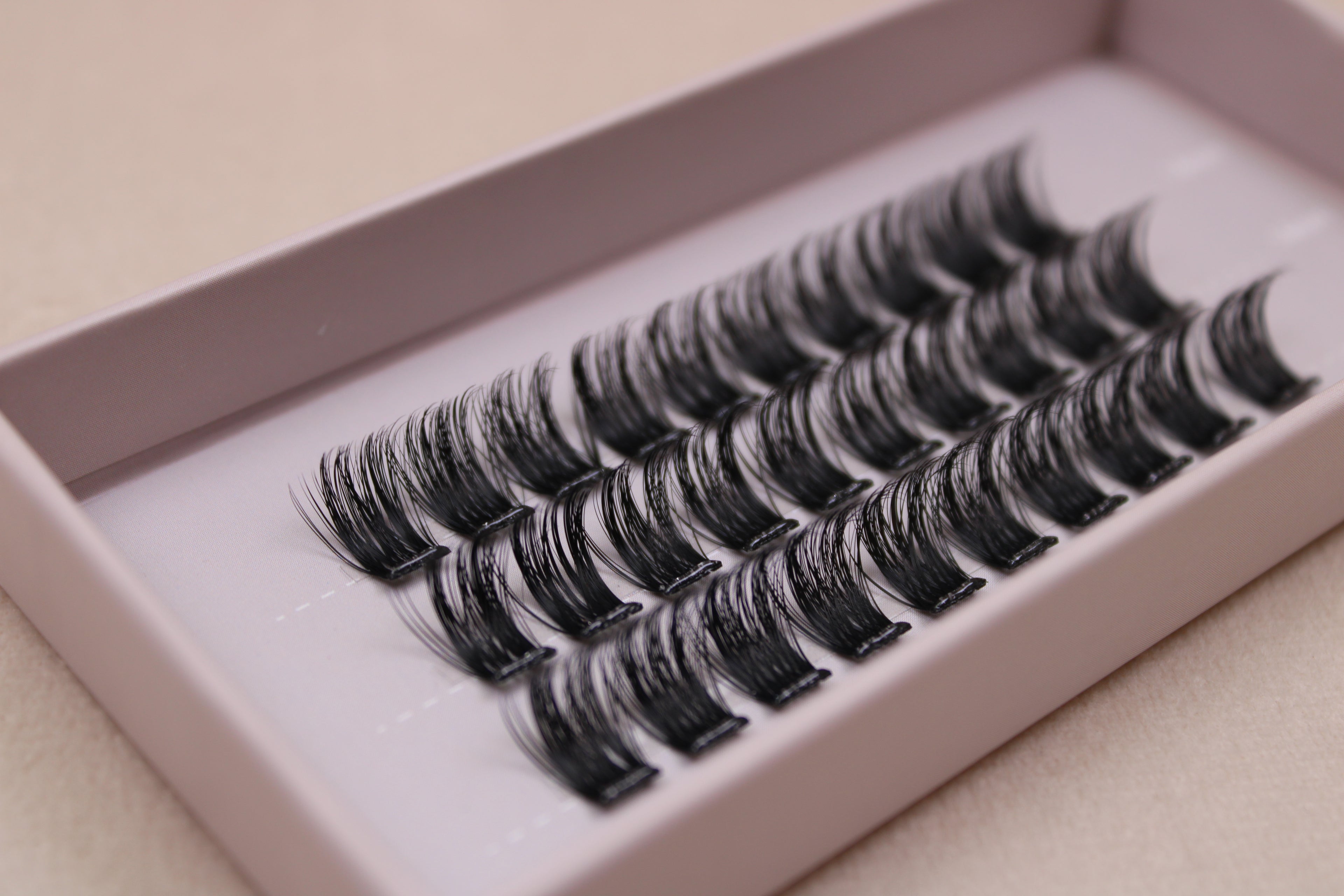 Vue rapprochée de faux cils en clusters 14 mm montrant la structure du bouquet de cils.