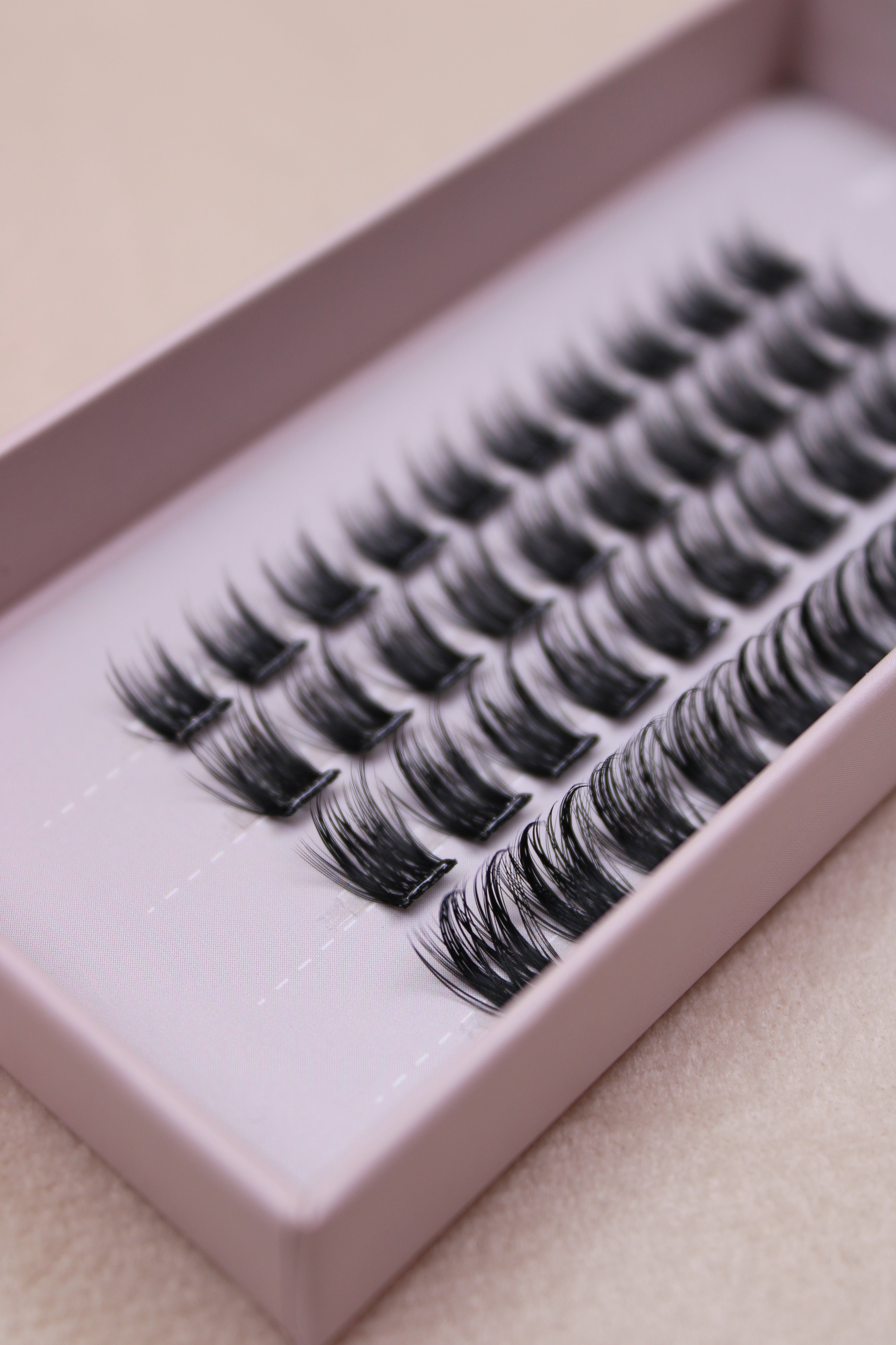 Gros plan sur des faux cils en clusters 12 mm montrant la densité et la courbure des fibres.
